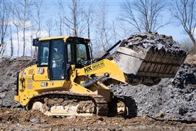 Site & Land Development: A Caterpillar 963 trackloader prepares to load a truck with material. 